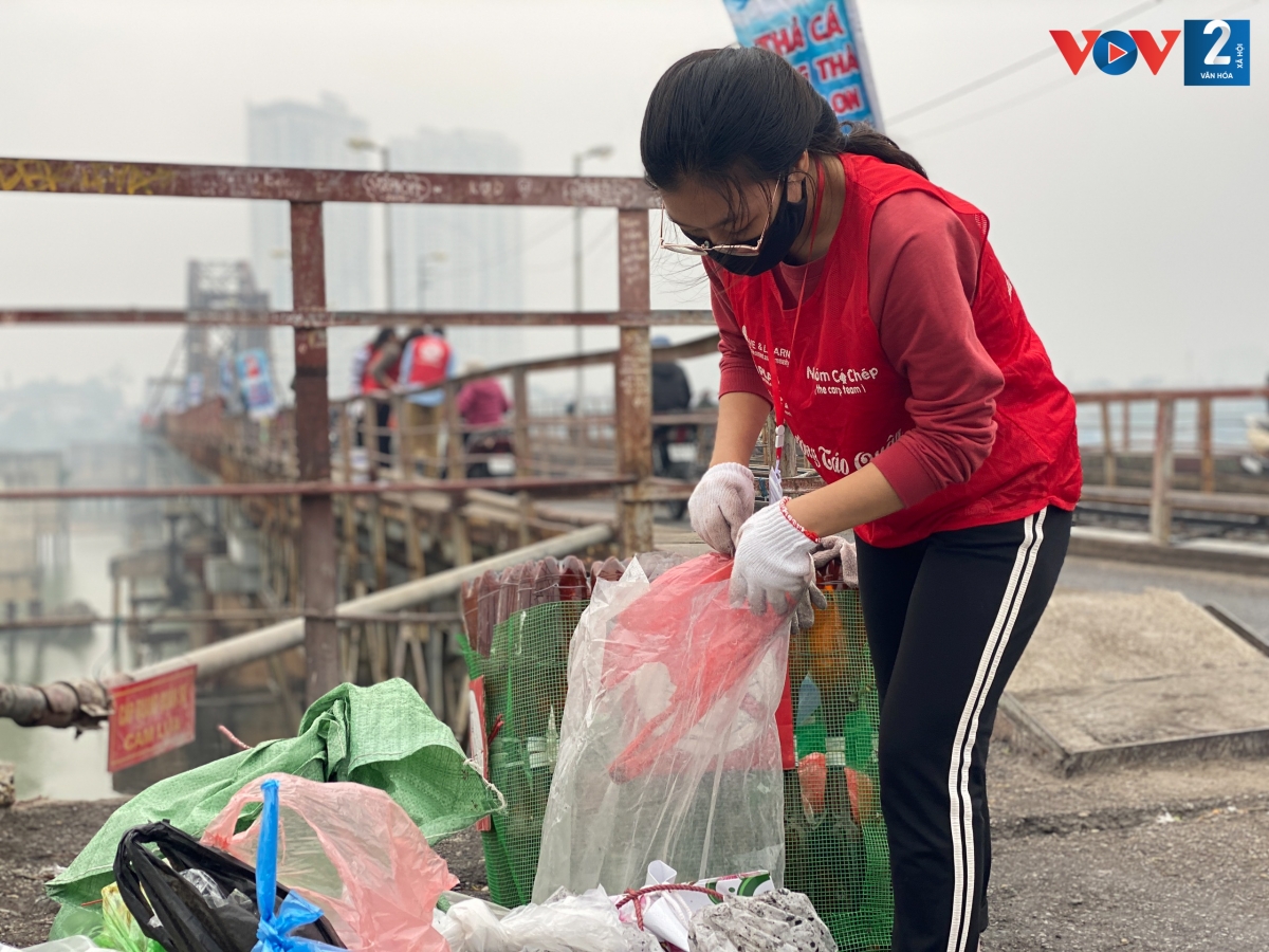 Phía trên cầu, các thành viên sẽ thu gom rác thải, vàng mã... sau khi người dân thả cá tiễn ông Táo về chầu.