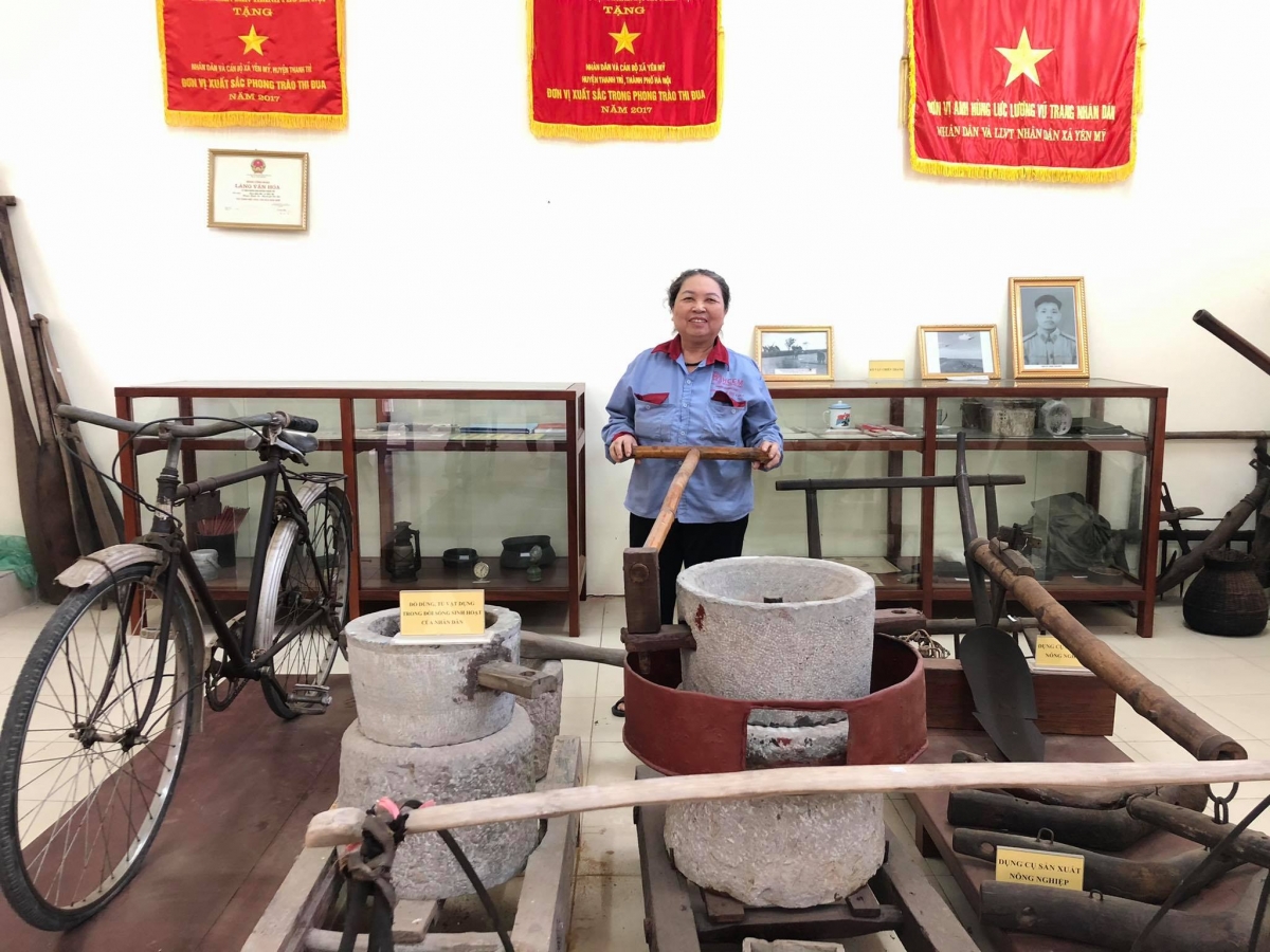 Bà Trần Thị Huệ người trông coi "bảo tàng" bên cạnh chiếc cối đá xay ngô