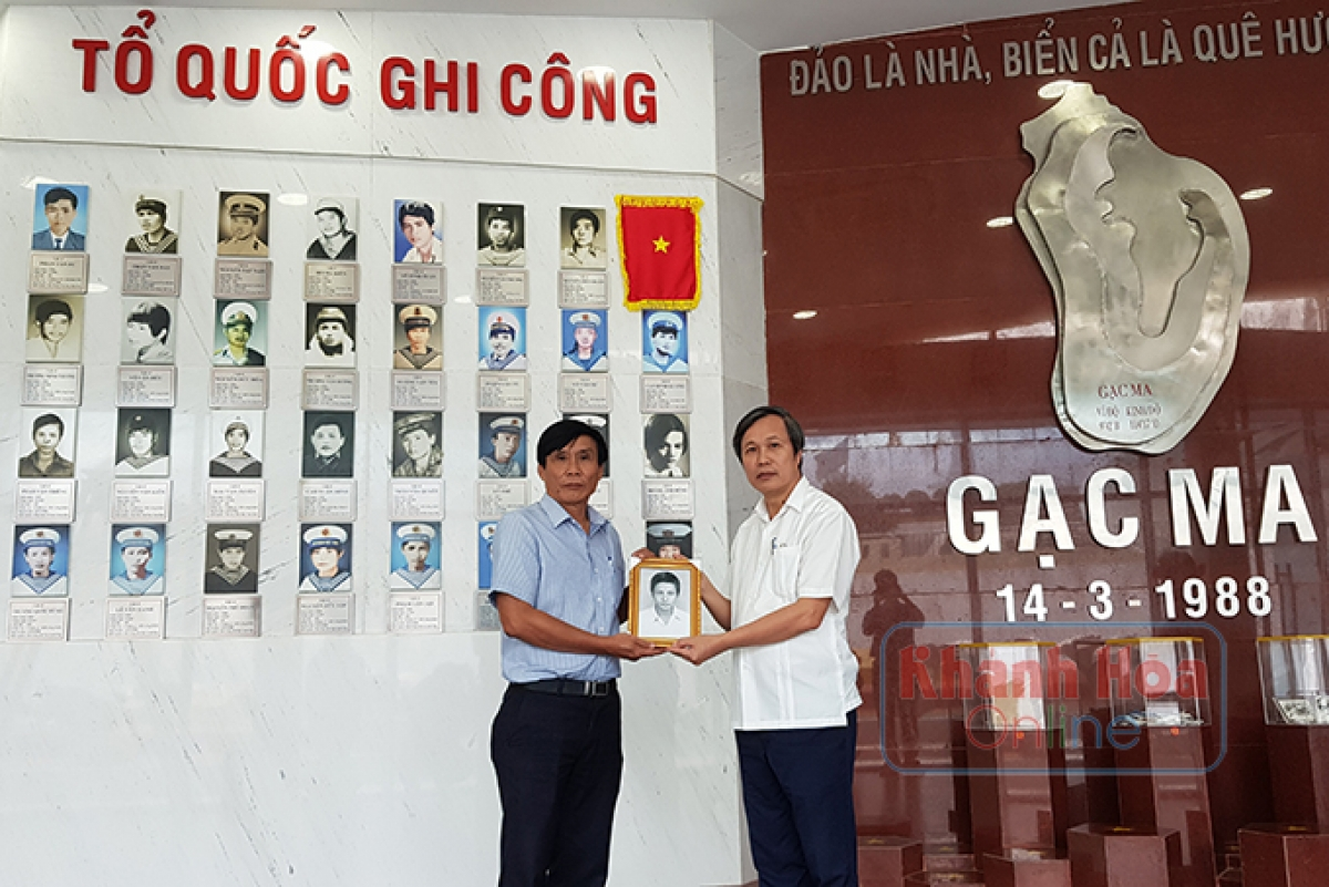 PGS-TS Ngô Văn Minh trao di ảnh cho ông Võ Duy Trúc,
Ban quản lý Khu tưởng niệm chiến sĩ Gạc Ma
