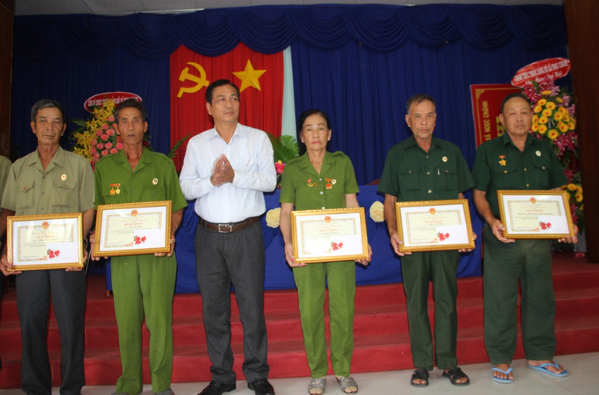 Phó Chủ tịch UBND tỉnh Trần Hồng Quân trao bằng khen và chụp hình lưu niệm cùng “Biệt đội cựu chiến binh vá đường”