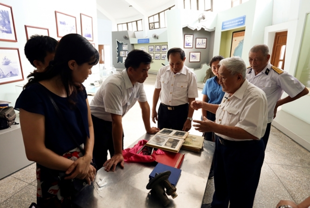 Ông Trương Thế Hùng giới thiệu với khách tham quan những tư liệu, hiện vật về rà phá thủy lôi