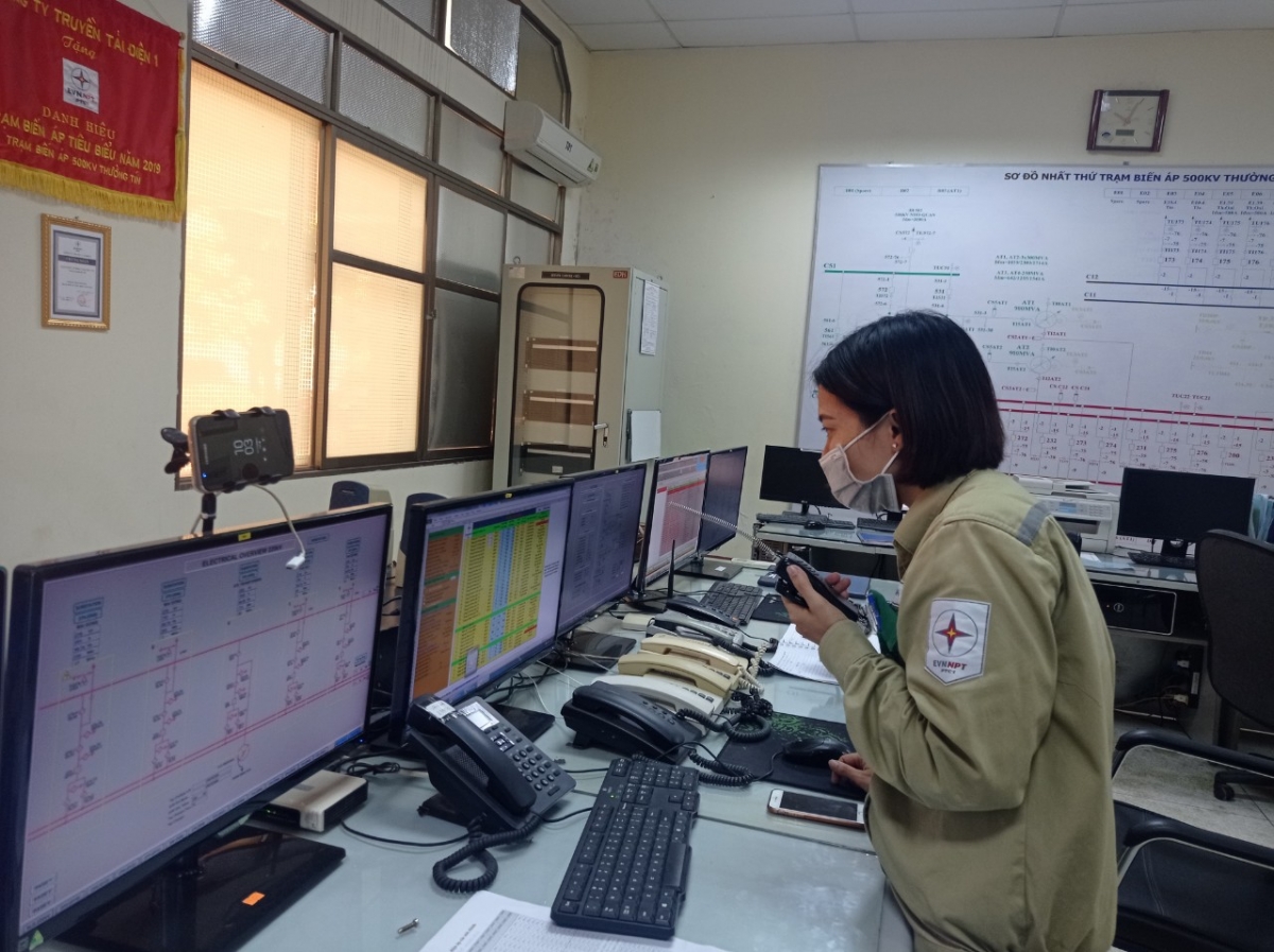 Tải đạt trên 80%, chị Thanh Hường - trực phụ trạm 500kV Thường Tín dùng bộ đàm báo cho đội kiểm tra thiết bị ngoài trời