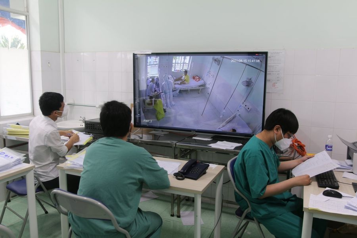 Các y, bác sĩ tại Trung tâm Hồi sức tích cực Tiền Giang đang theo dõi quá trình chăm sóc bệnh nhân qua camera.