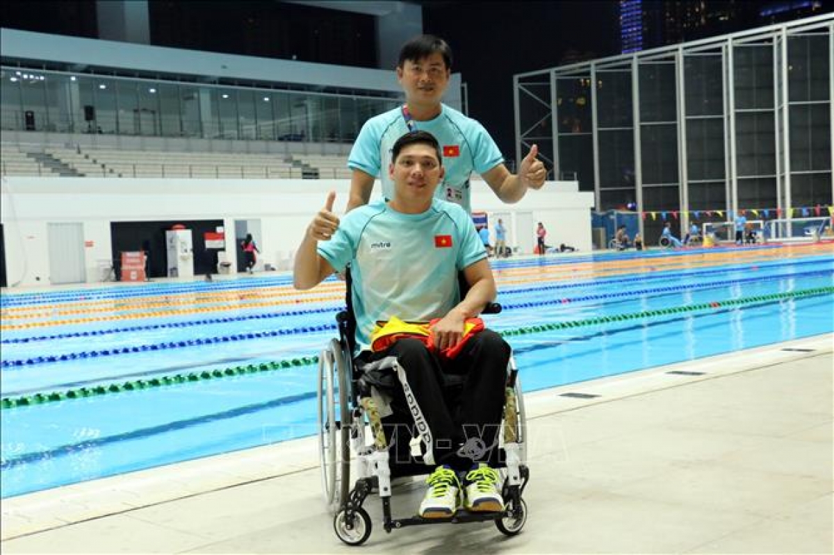 Thanh Tùng cùng huấn luyện viên sau khi kết thúc nội dung thi đấu bơi 50m tự do, tại Asian Para Games 2018 (Ảnh TTXVN)