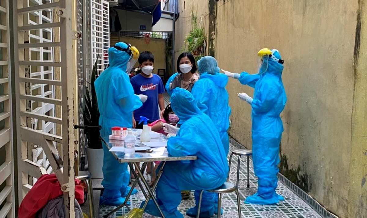 Lực lượng y tế lấy mẫu xét nghiệm của các hộ dân cạnh nhà ca nghi nhiễm Covid-19