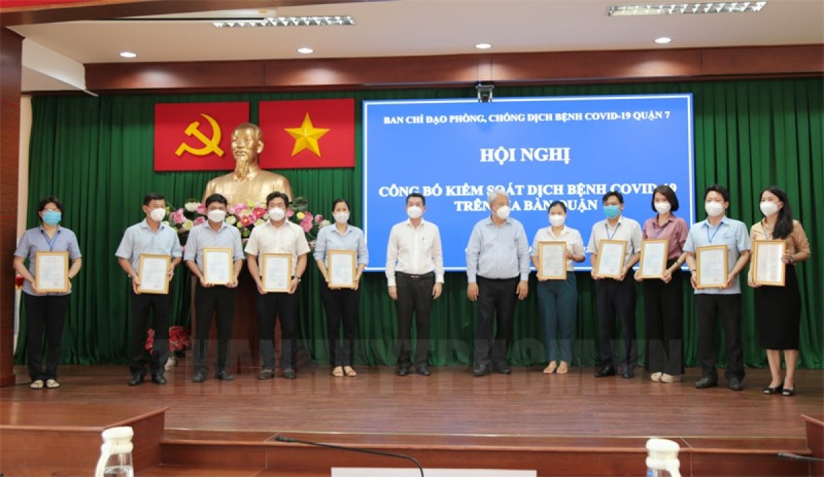 Bí thư Quận ủy Nguyễn Khắc Thái và Chủ tịch UBND Quận 7 Hoàng Minh Tuấn Anh trao chứng nhận đã kiểm soát dịch Covid-19 cho 10 phường (Ảnh Trang tin điện tử Đảng bộ TP. HCM)
