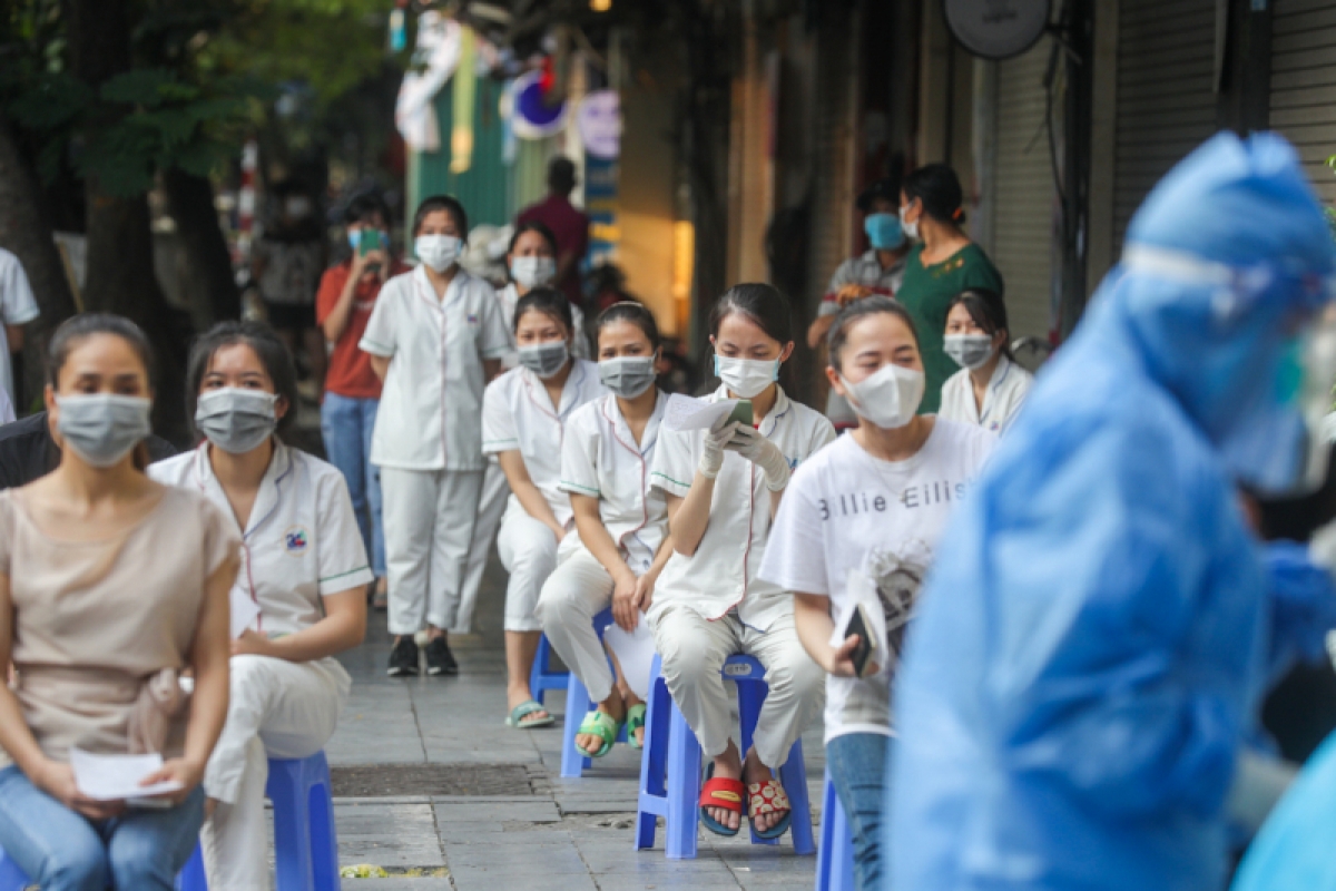 Nhân viên hiệu thuốc và người dân gần Bệnh viện Việt Đức được lấy mẫu xét nghiệm. (Ảnh: Phong Sơn)