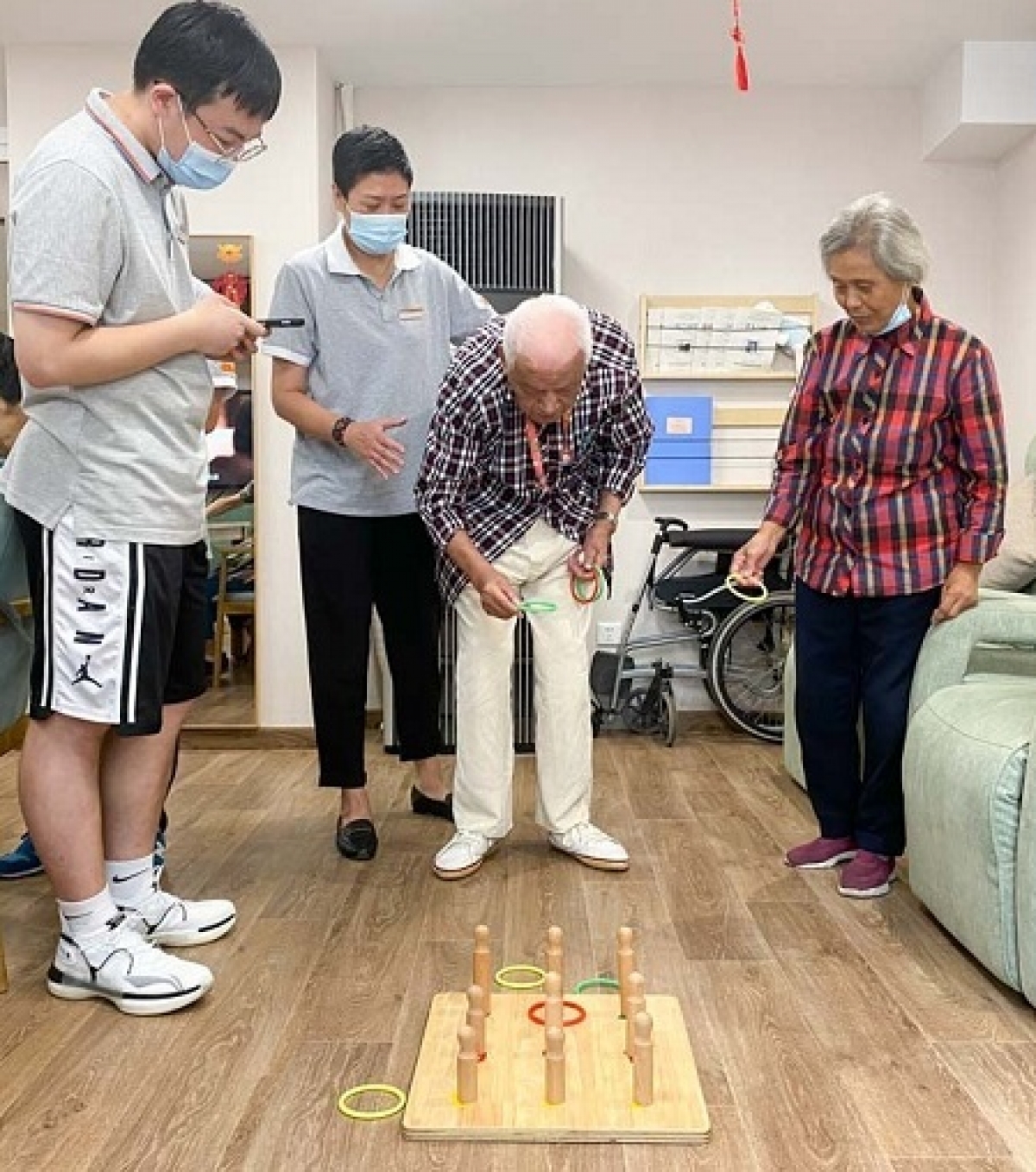 Zhong Zhixiang (giữa) chơi trò ném vòng tại Trung tâm chăm sóc người cao tuổi tích hợp Huayang, Thượng Hải, ngày 20 tháng 8 năm 2021. Ảnh: Sixthtone