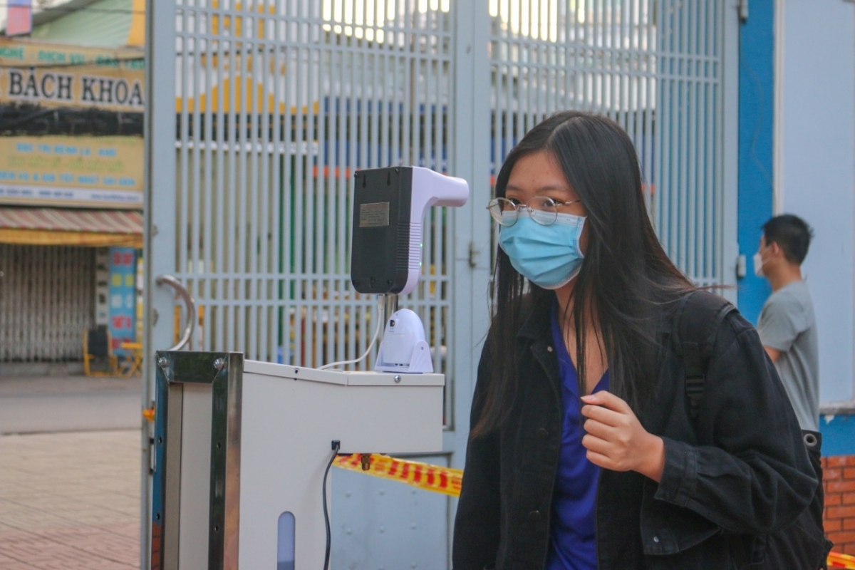 Học sinh đo thân nhiệt tại cổng trường THPT Nguyễn Du, Quận 10, TPHCM