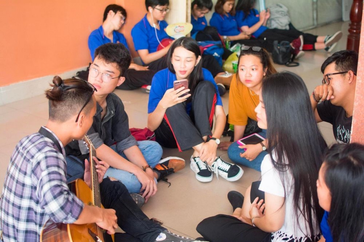 Thuỳ Tiên cùng nhiều sinh viên khác ngồi quây quần đàn hát sau những giờ học tập tại trường (Ảnh: Câu lạc bộ Guitar Nhân Văn)