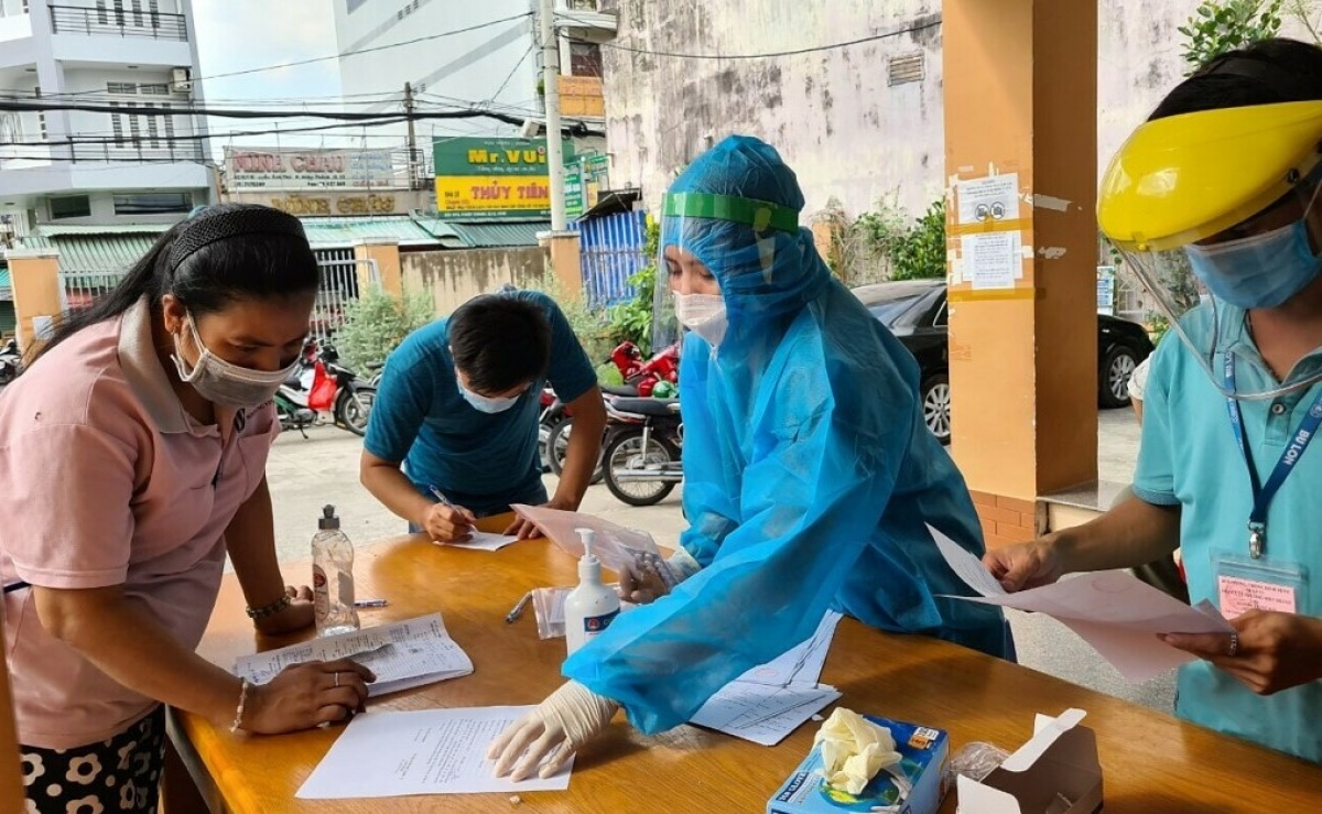 Nhân viên Trạm y tế phường Hiệp Thành, quận 12, hướng dẫn F0 hoàn tất các giấy tờ liên quan cách ly tại nhà