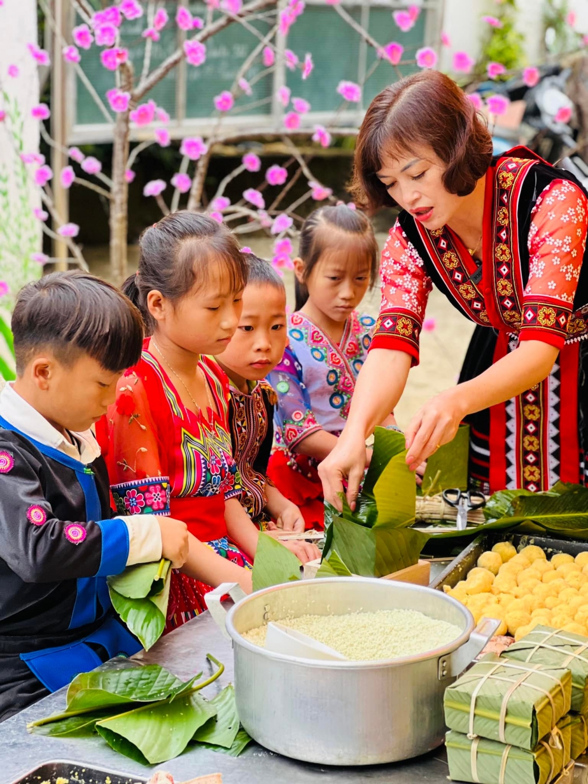 Cô Mai Thị Ánh Hồng, Hiệu trưởng trường tiểu học Nùng Nàng hướng dẫn học sinh gói bánh chưng.
