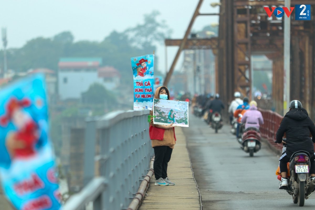 Dọc hai bên cầu Long Biên treo nhiều khẩu hiệu tuyên truyền về cách thả cá chép.