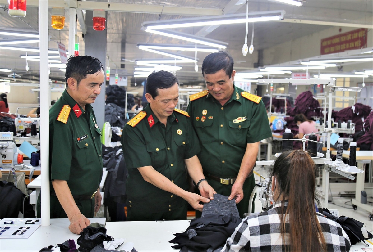 Doanh nhân CCB Trần Văn Thư (bên phải) kiểm tra hàng tại xưởng may.