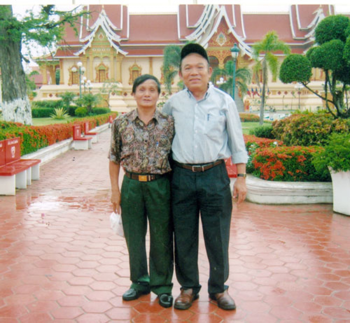 Cựu chiến binh Nguyễn Đức Chuyển (bìa trái) và ông Xaraphot Ratdara tại chùa That Luang (Ảnh do ông Chuyển cung cấp)
