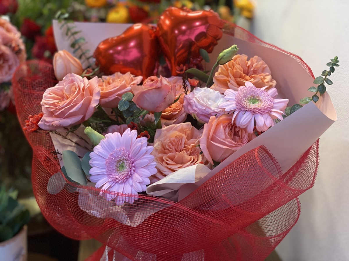 Năm nay, thợ cắm hoa thiết kế thêm các phụ kiện bóng bay trái tim, gắn thêm lời nhắn trên các bó hoa theo yêu cầu của khách hàng.