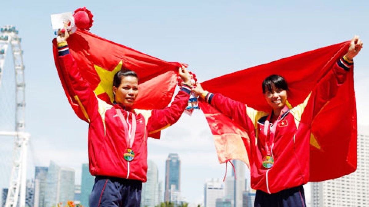 VĐV Phạm Thị Huệ (trái) cùng đồng đội mang HCV về cho Đoàn Thể thao Việt Nam tại SEA Games 28, tổ chức ở Sìngapore