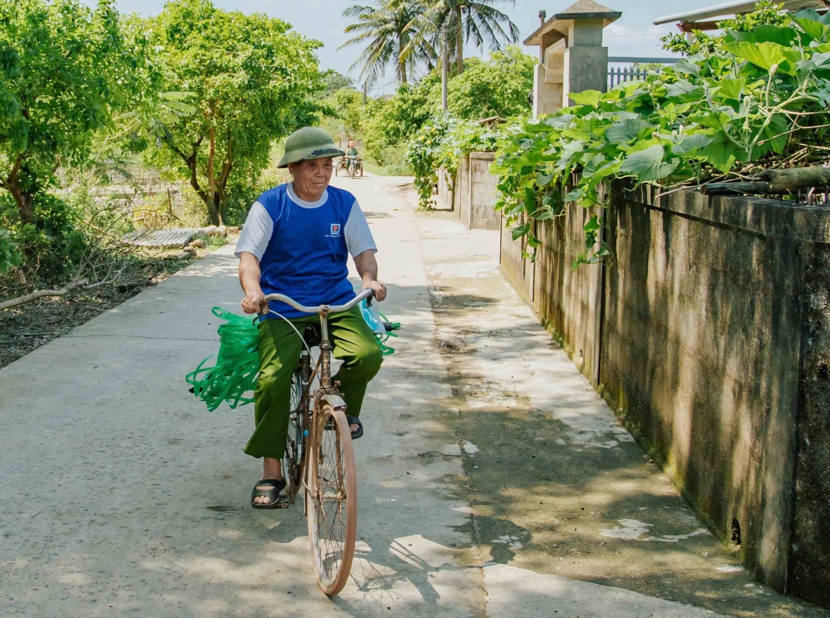 Ông Tụng đạp xe đi khắp xóm thu gom những sợi dây nhựa dùng để buộc hàng bị thải bỏ