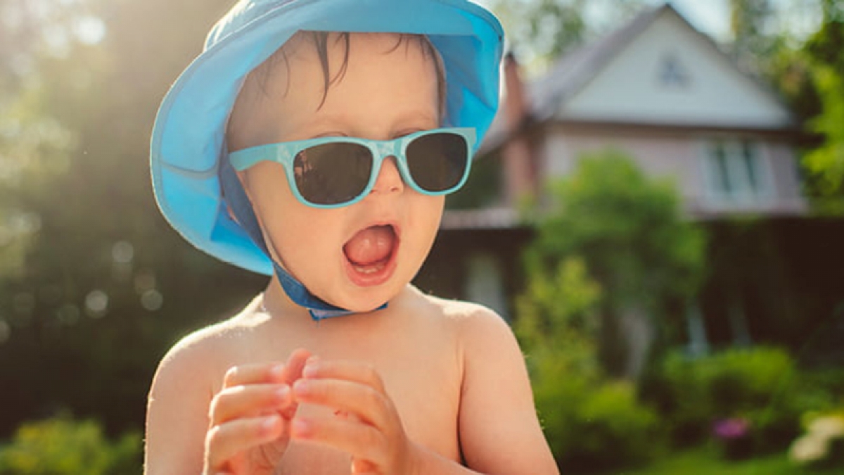Khi trẻ vui chơi, hoạt động ngoài trời dưới nắng hè, nên đeo kính, đội mũ để ngăn ngừa tia tử ngoại