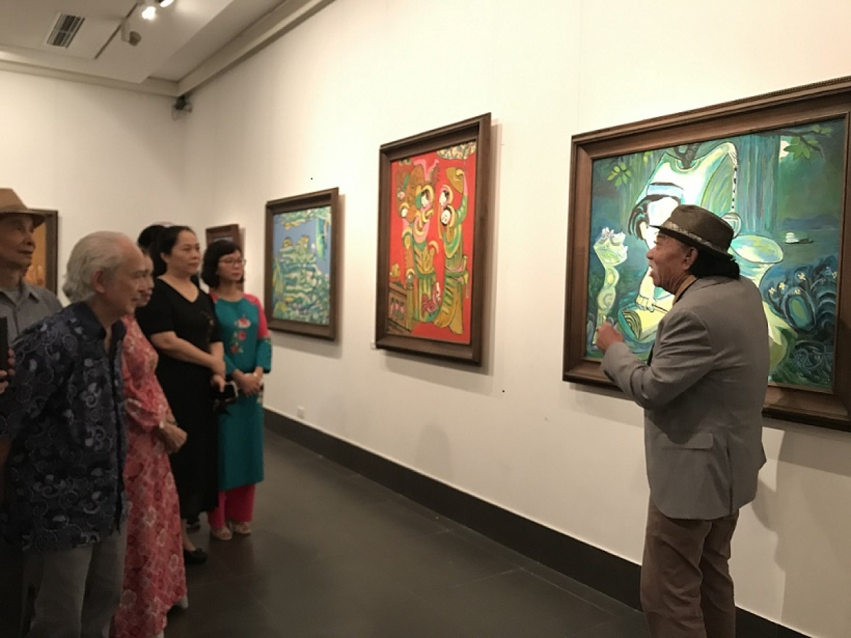 Họa sĩ Nguyễn Đại Giang giới thiệu tác phẩm của mình với khách xem triển lãm