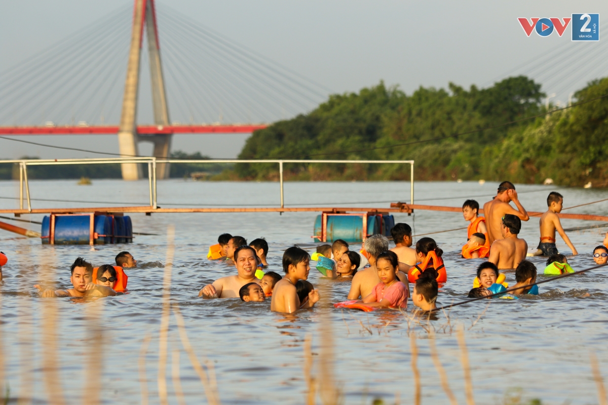 Ghi nhận của PV VOV2, chiều 27/6, từ 16h30 đã có rất đông người dân kéo nhau ra bãi tắm tự phát ven sông Hồng thuộc phường Phú Thượng, quận Tây Hồ để giải nhiệt.