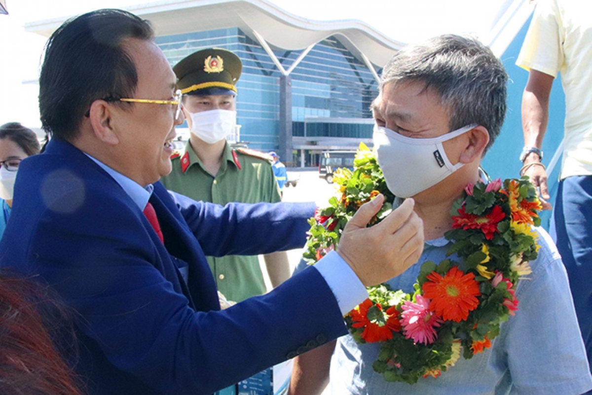 Ông Lê Hữu Hoàng - Phó Chủ tịch Thường trực UBND tỉnh Khánh Hòa tặng hoa cho du khách trên chuyến bay Singapore - Cam Ranh