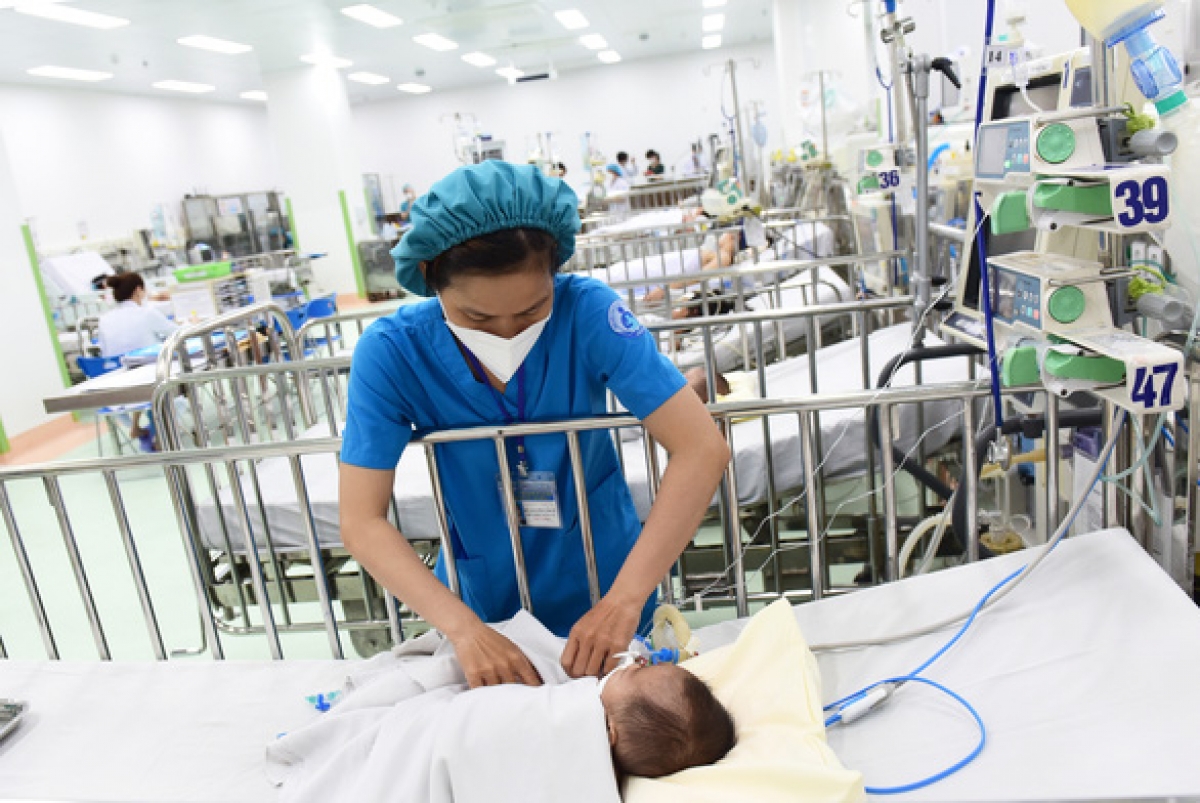 Nhân viên y tế chăm sóc cho bệnh nhi điều trị sốt xuất huyết tại Bệnh viện Nhi đồng 1, TP.HCM