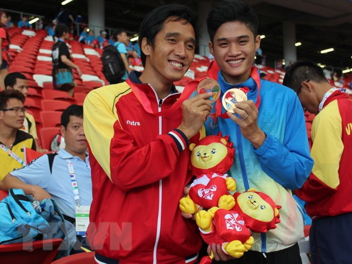 Vận động viên Nguyễn Ngọc Hiệp (áo đỏ) giành huy chương đồng chạy 400m tại ASEAN Para Games lần thứ 8. (Ảnh: TTXVN)