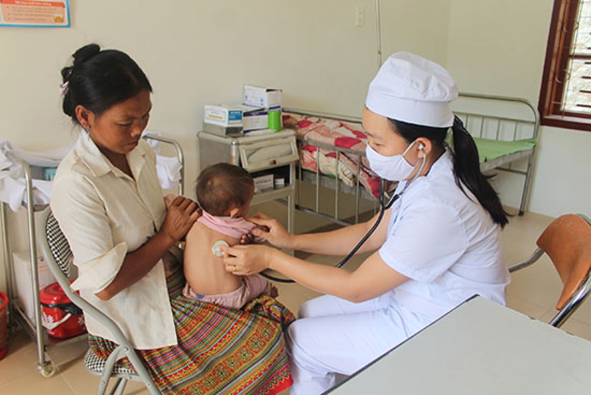 Cán bộ Trạm Y tế xã Hồng Ngài, Bắc Yên, Sơn La khám bệnh cho bệnh nhi.