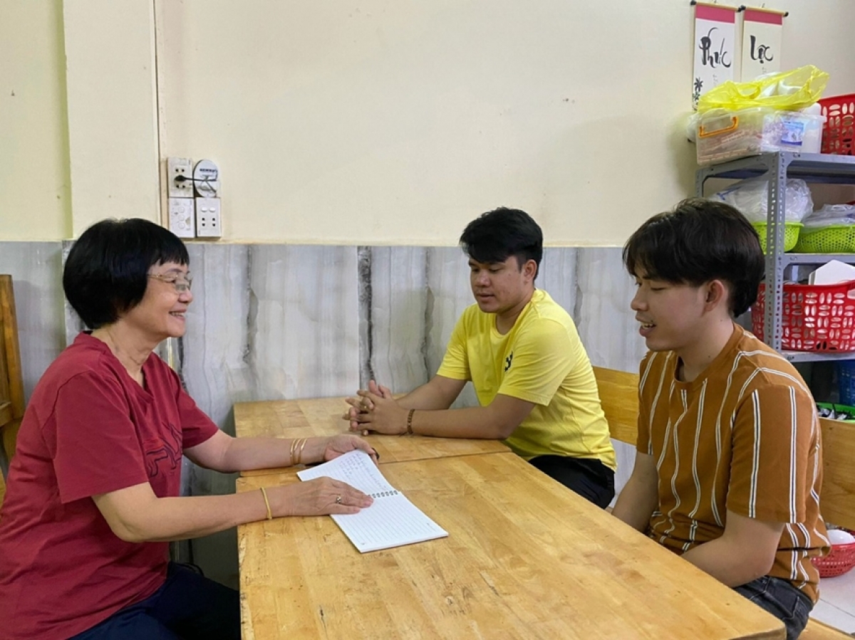 Bà Dương Thị Kim Dung trò chuyện, thăm hỏi tình hình học tập của hai con nuôi là sinh viên Lào