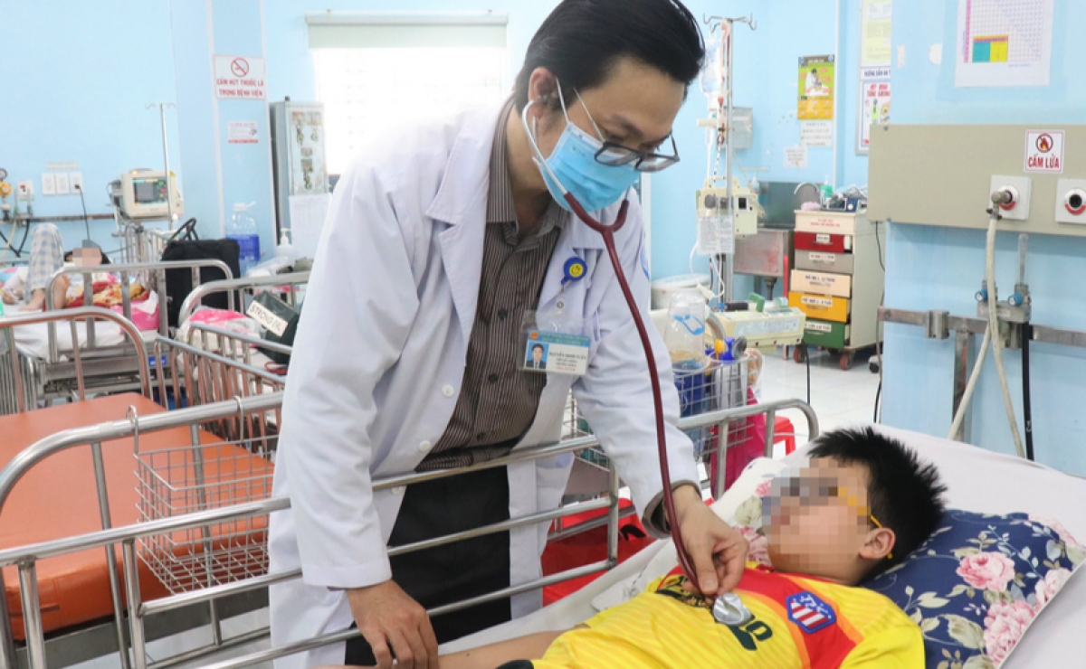 TS.BS Nguyễn Minh Tuấn - Trưởng khoa Sốt xuất huyết - Huyết học Bệnh viện Nhi đồng 1 (TP HCM), thăm khám bệnh nhân bị sốt xuất huyết. (Ảnh: Xuân Mai)
