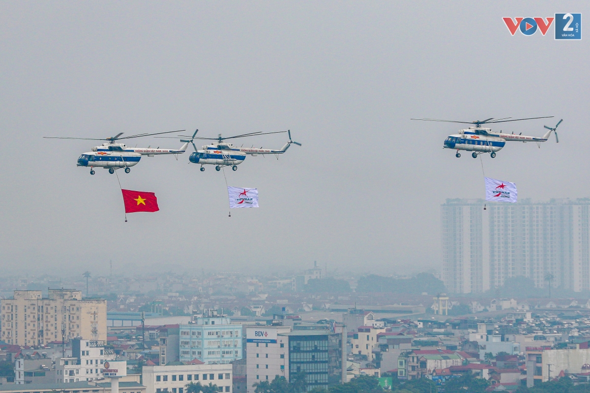 Các biên đội trực thăng Mi mang quốc kỳ và cờ biểu trưng của Triển lãm Quốc phòng quốc tế Việt Nam 2022 thiết lập đội hình trên không.