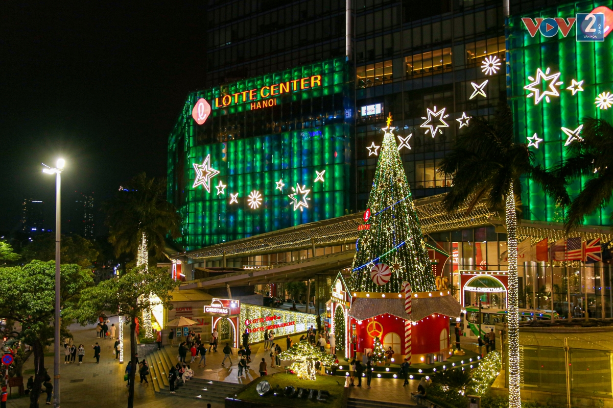 Tại trung tâm thương mại trên phố Đào Tấn (Liễu Giai, Ba Đình), một cây thông khổng lồ được dựng ngay phía dưới chân của tòa nhà, trang trí rực rỡ thu hút người dân tới chụp ảnh, vui chơi.