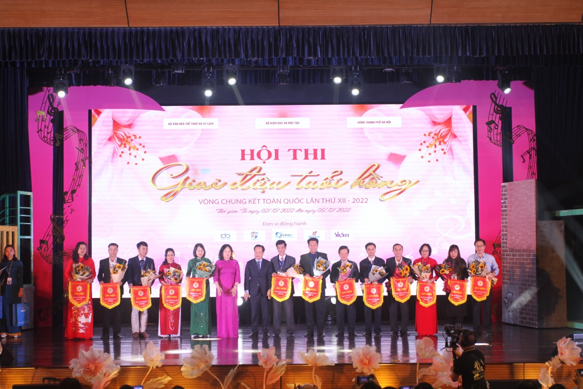 Thứ trưởng Bộ GD-ĐT Ngô Thị Minh và Giám đốc Sở GD-ĐT Hà Nội Trần Thế Cương trao cờ lưu niệm cho các đoàn tham dự Hội thi "Tiếng hát tuổi hồng" lần thứ 12.