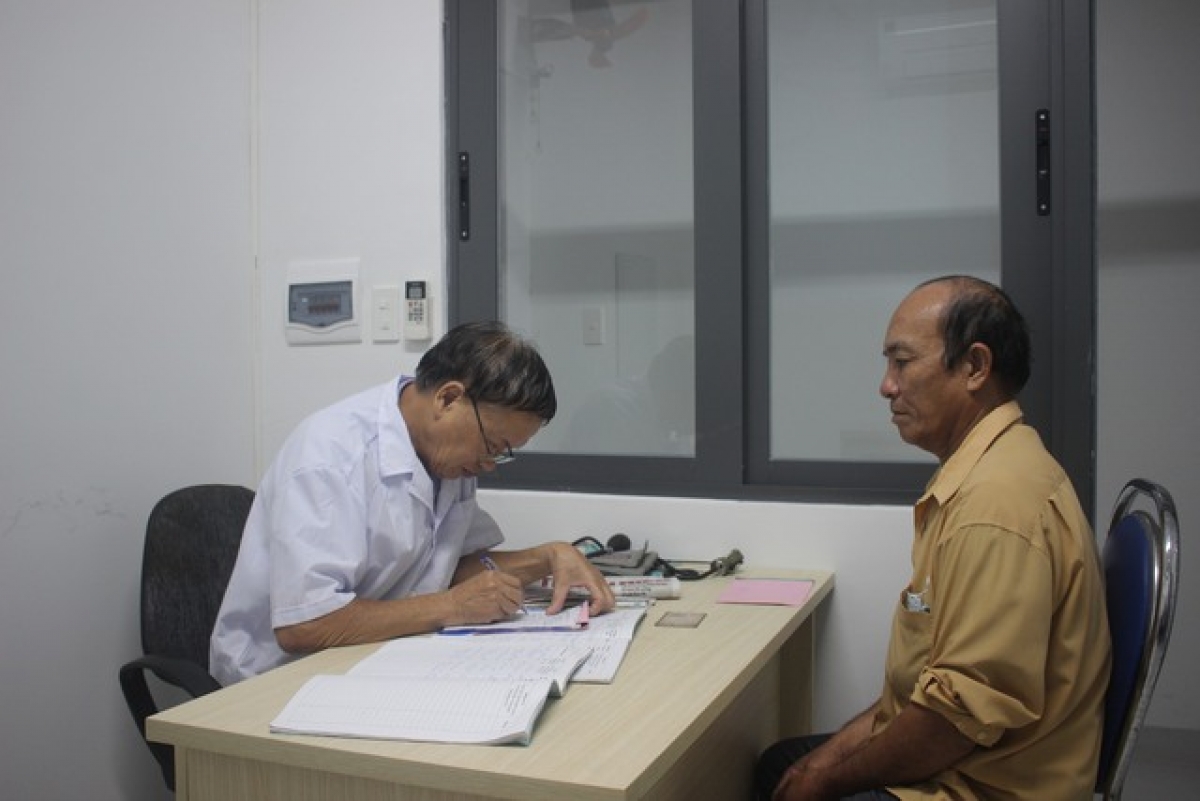 Ở tuổi thất thập, y sĩ Nguyễn Văn Toại (bên trái) vẫn miệt mài khám bệnh miễn phí