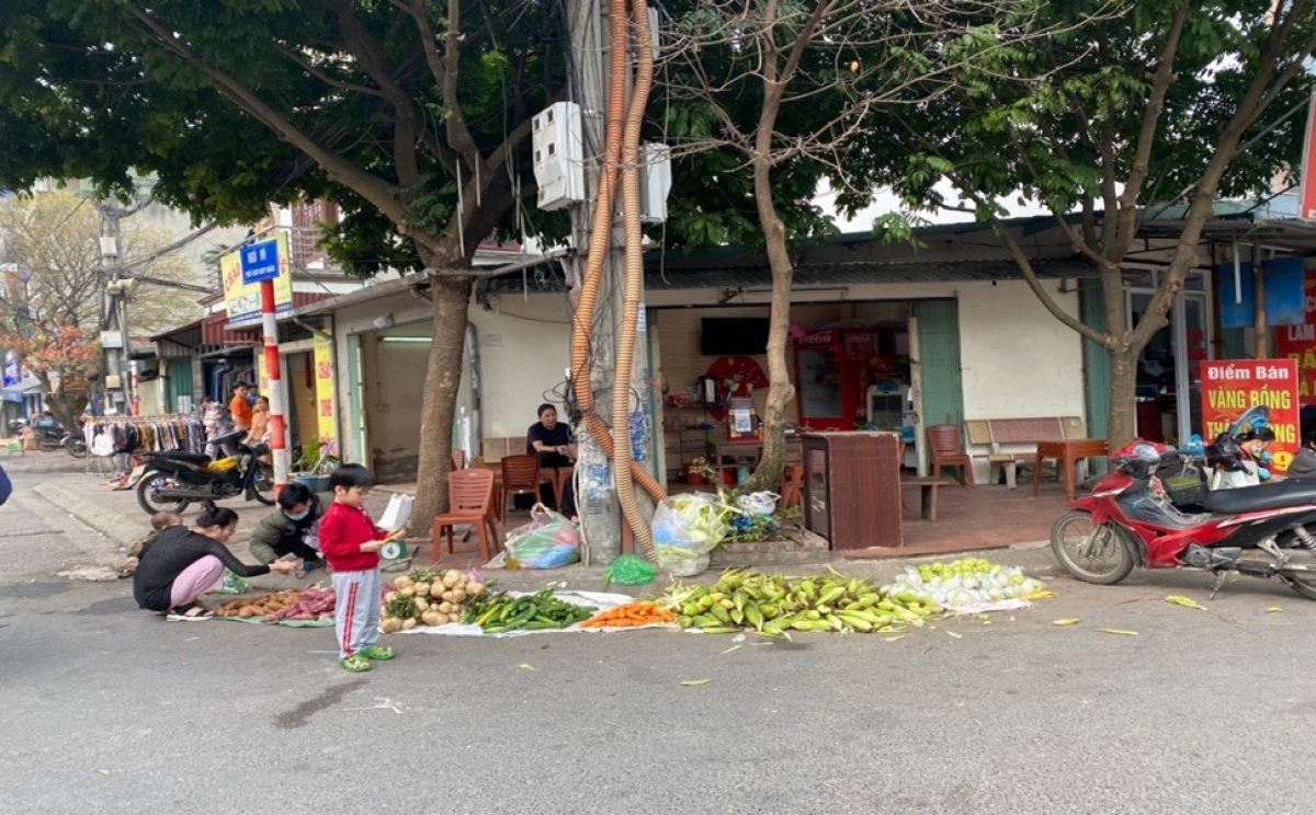 Người dân bày bán rau củ dưới lòng đường, ngay khúc cua phố Chu Huy Mân (quận Long Biên)