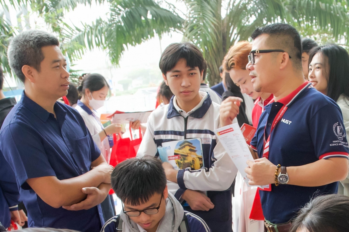                 PGS.TS Phạm Quang (ngoài cùng bên phải) đang tư vấn cho thí sinh và phụ huynh 