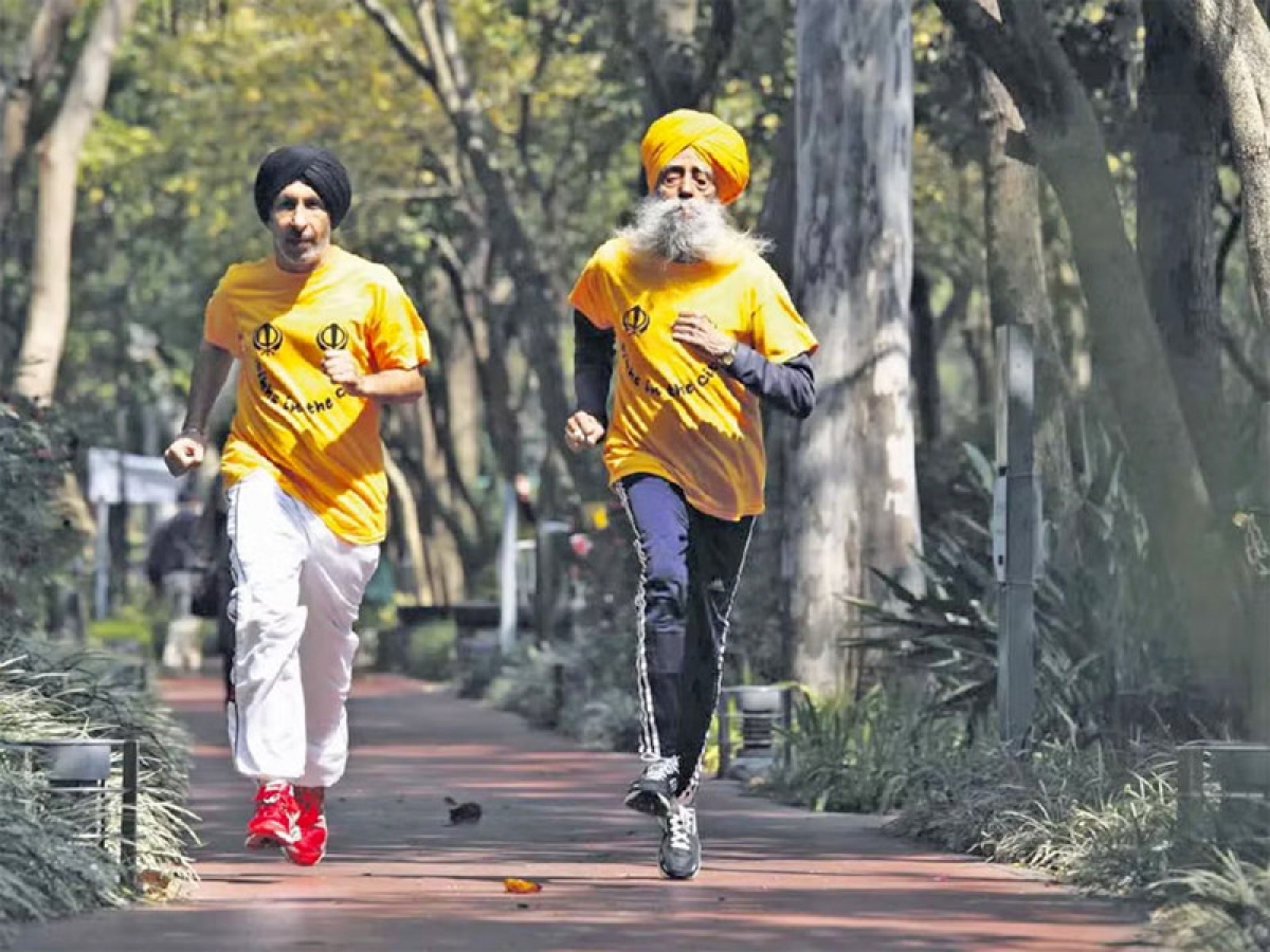 Cụ Fauja Singh chạy với huấn luyện viên của mình. Ảnh: Reuters