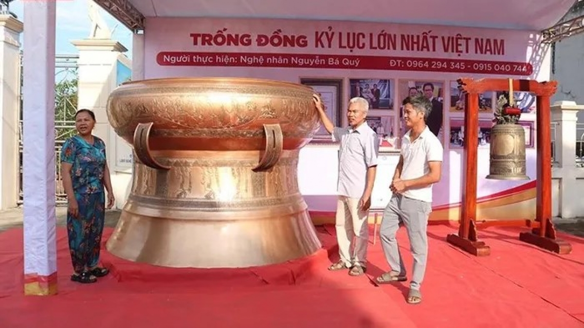 Nghệ nhân Nguyễn Bá Quý (ngoài cùng bên phải) cùng phiên bản trống đồng Ngọc Lũ lớn nhất Việt Nam