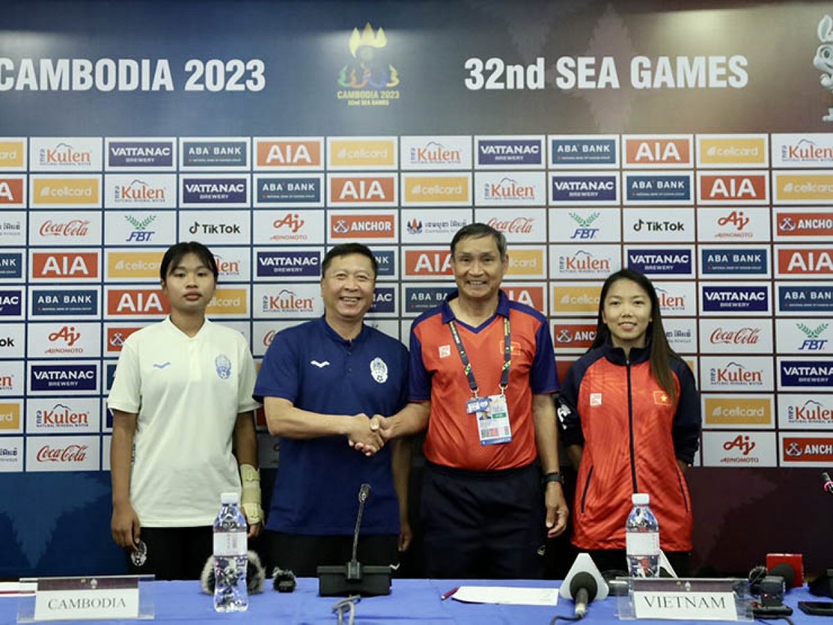 HLV và cầu thủ 2 đội nữ Campuchia và Việt Nam chụp ảnh lưu niệm tại cuộc họp báo trước thềm trận bán kết môn bóng đá nữ SEA Games 32.