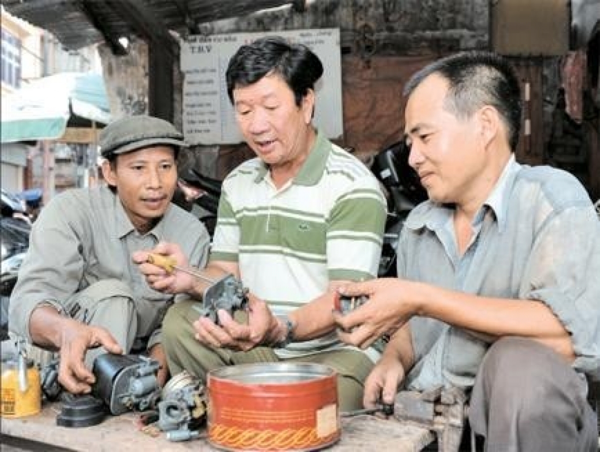 Ông Nguyễn Viết Vân đang hướng dẫn các thành viên trong CLB cách sửa xe máy
