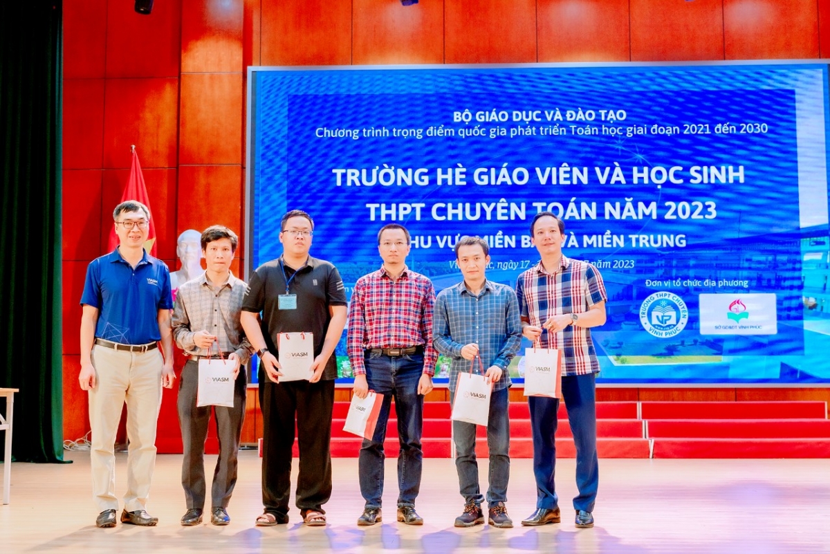 TS Lê Minh Hà - Giám đốc điều hành Viện Nghiên cứu cao cấp về Toán ( bìa trái ) tặng quà lưu niệm cho các thầy giáo đại diện cho các trường THPT chuyên khu vực miền Bắc có học sinh tham gia Trường hè toán học  2023 