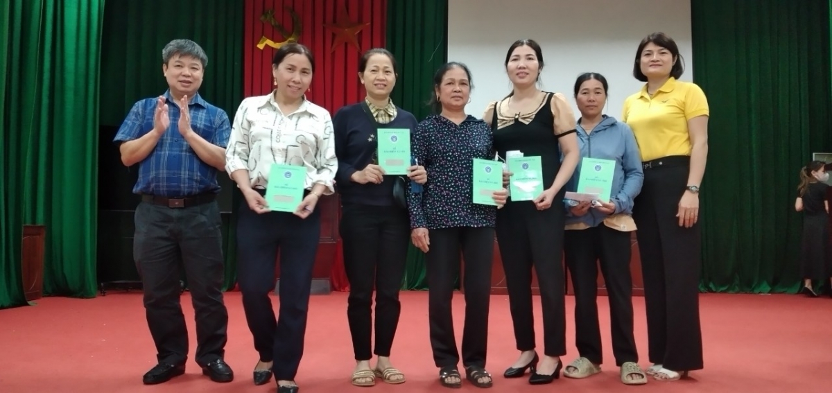 Ông Ngô Xuân Giang, Giám đốc BHXH huyện Ứng Hòa (ngoài cùng bên trái) trao tặng sổ BHXH tự nguyện cho người dân