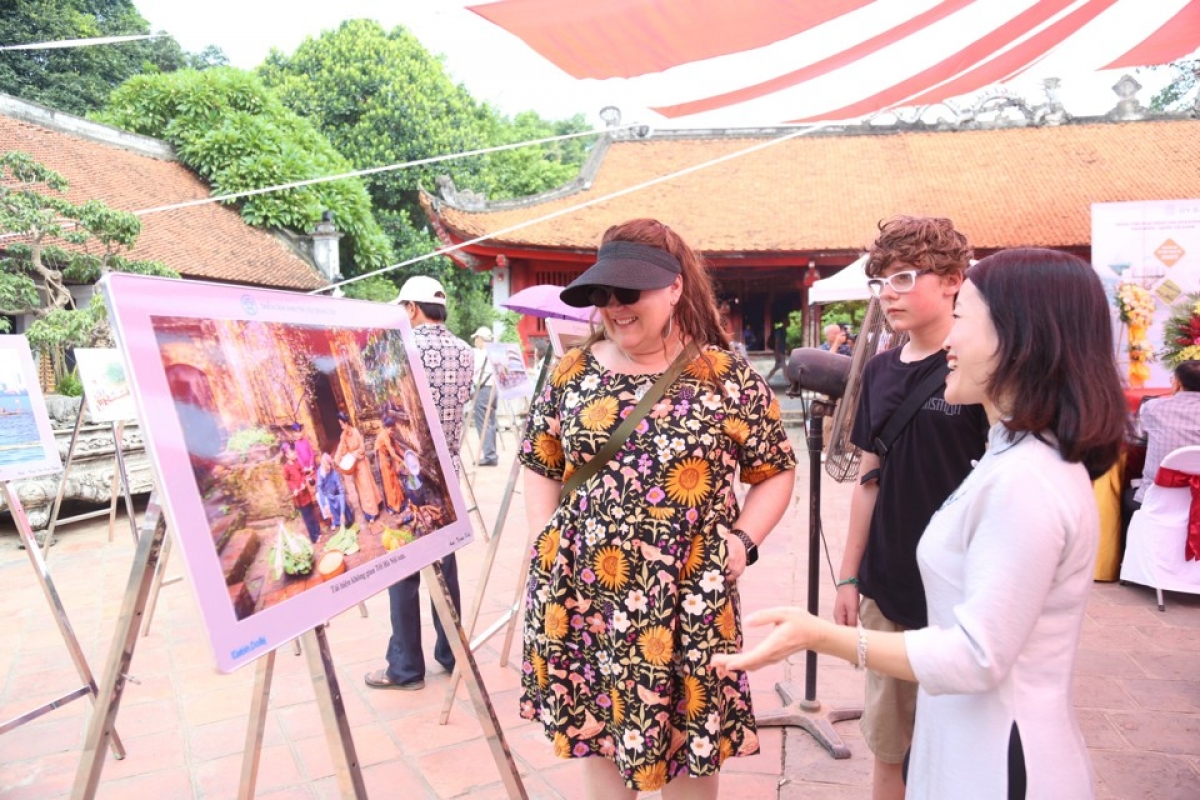 Du khách nước ngoài rất hào hứng khi cảm nhận được sự đổi thay tích cực của Thủ đô Hà Nội qua những tác phẩm trưng bày tại triển lãm. Ảnh: BTC