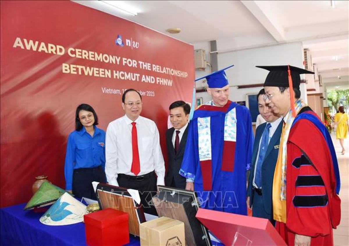 Các đại biểu tham quan phòng trưng bày "Tủ sách Việt Nam" do trường Đại học Bách khoa (ĐH Quốc gia TP.HCM) tặng Trường Đại học Khoa học Ứng dụng và Nghệ thuật Tây Bắc Thụy Sĩ.( Ảnh TTX Việt Nam )  