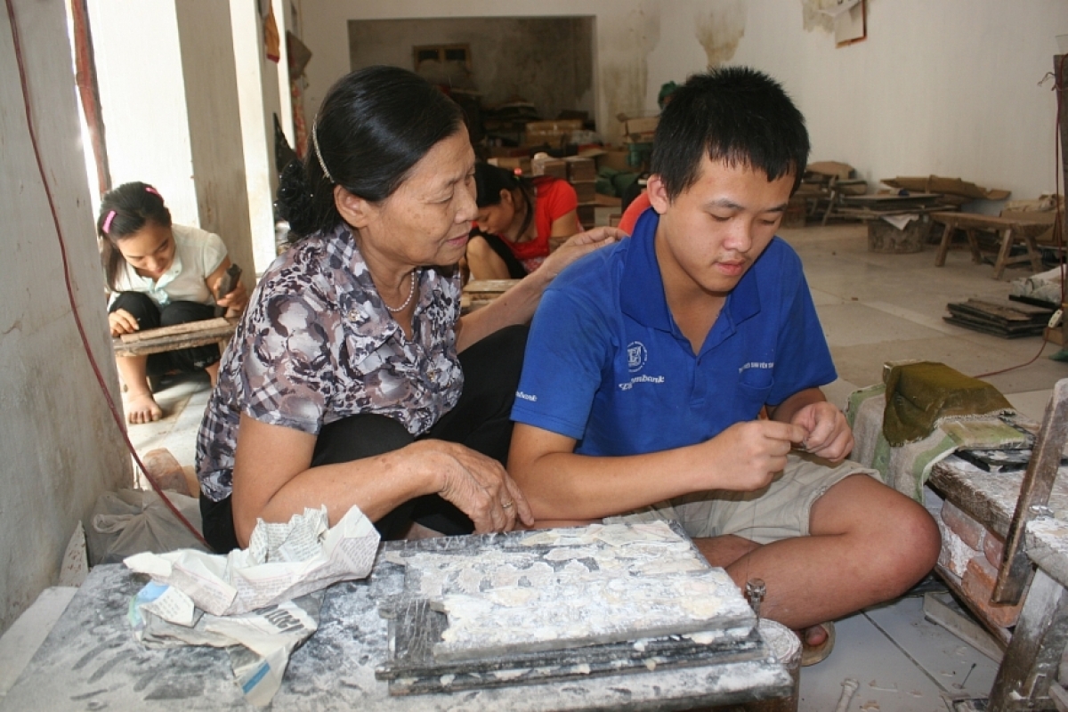 Bà Nguyễn Thị Vui tận tình dạy nghề cho trẻ em khuyết tật tại trung tâm.