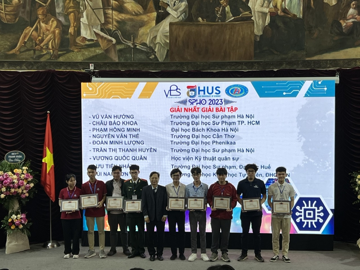 GS TSKH  Vũ Hoàng Linh - Hiệu trưởng Trường ĐHKHTN ĐHQGHN (đơn vị đăng cai SPHO25) trao giải nhất cho 9 sinh viên đạt giải nhất phần thi giải bài tập 