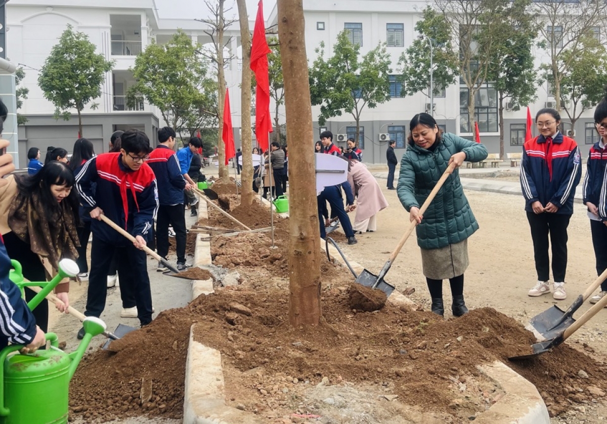 Học sinh cùng giáo viên trường THCS Trưng Vương (Mê Linh, Hà Nội) tham gia trồng cây