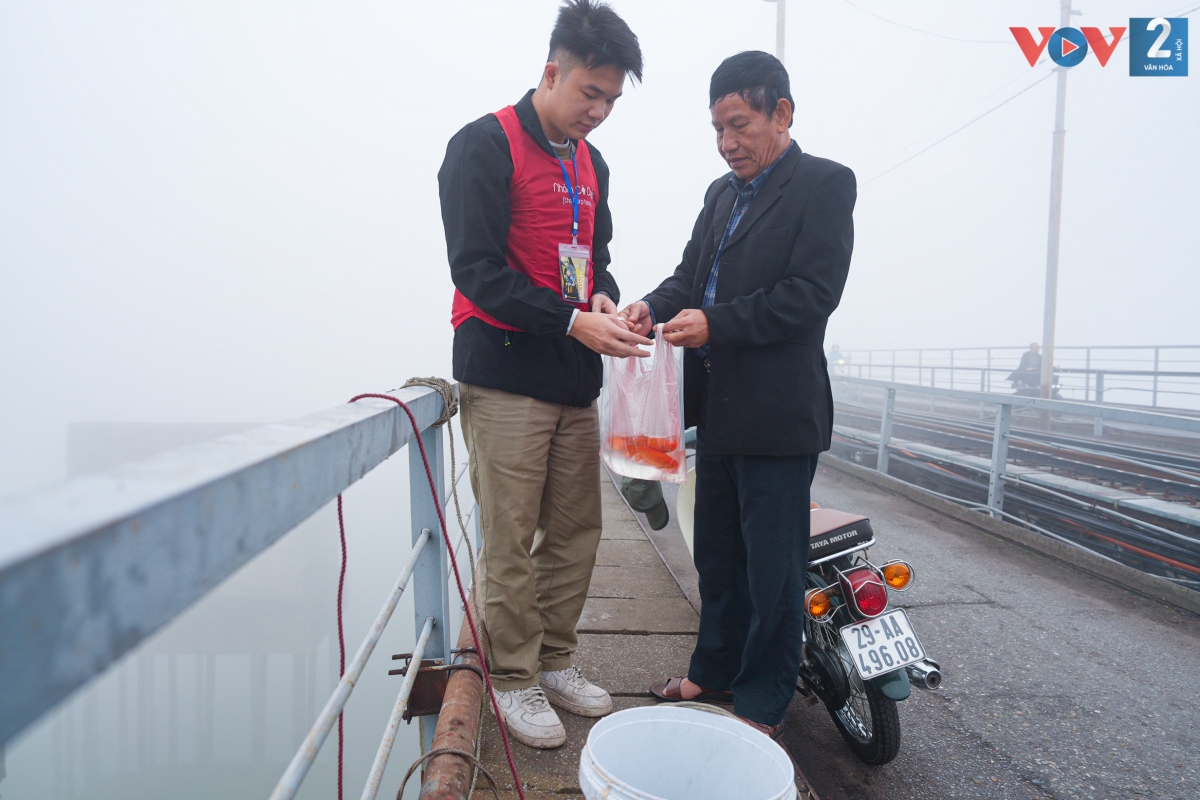 Nhiều người dân nhiệt tình ủng hộ giao cá cho các tình nguyện viên thả xuống sông.