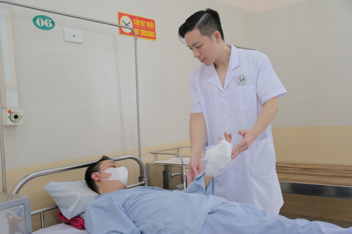 BS Phạm Duy Linh thăm khám cho bệnh nhân sau phẫu thuật. Ánh: BV cung cấp